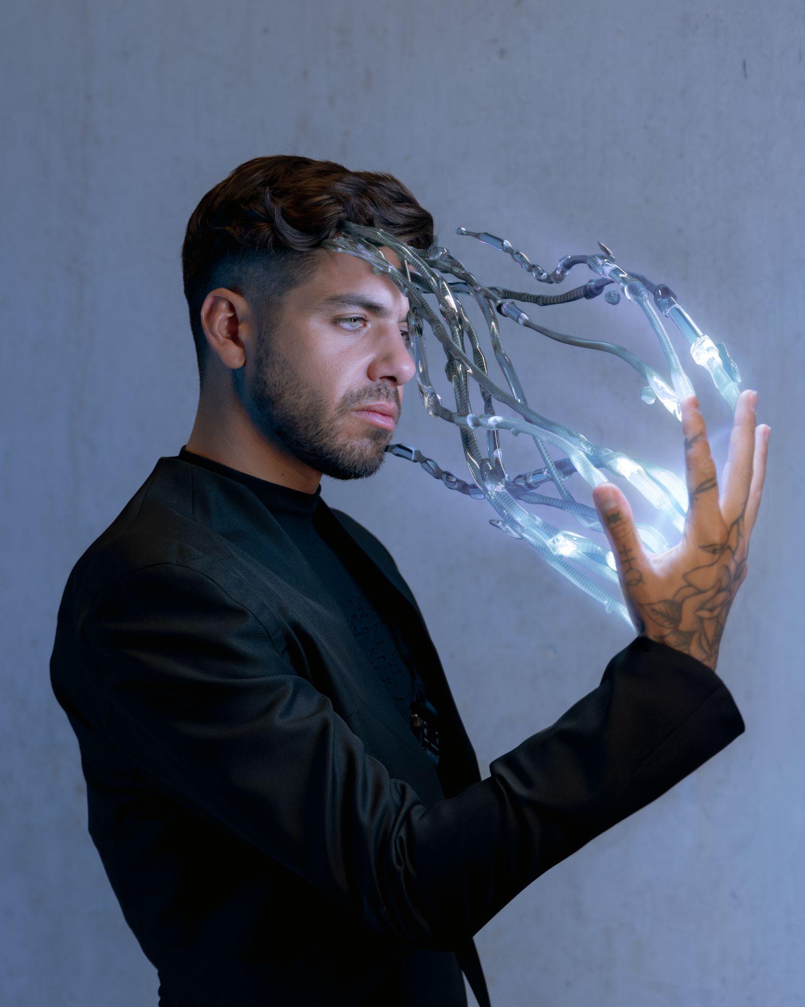 A musician with beams of light light and robot fingers emerging from his hand. 