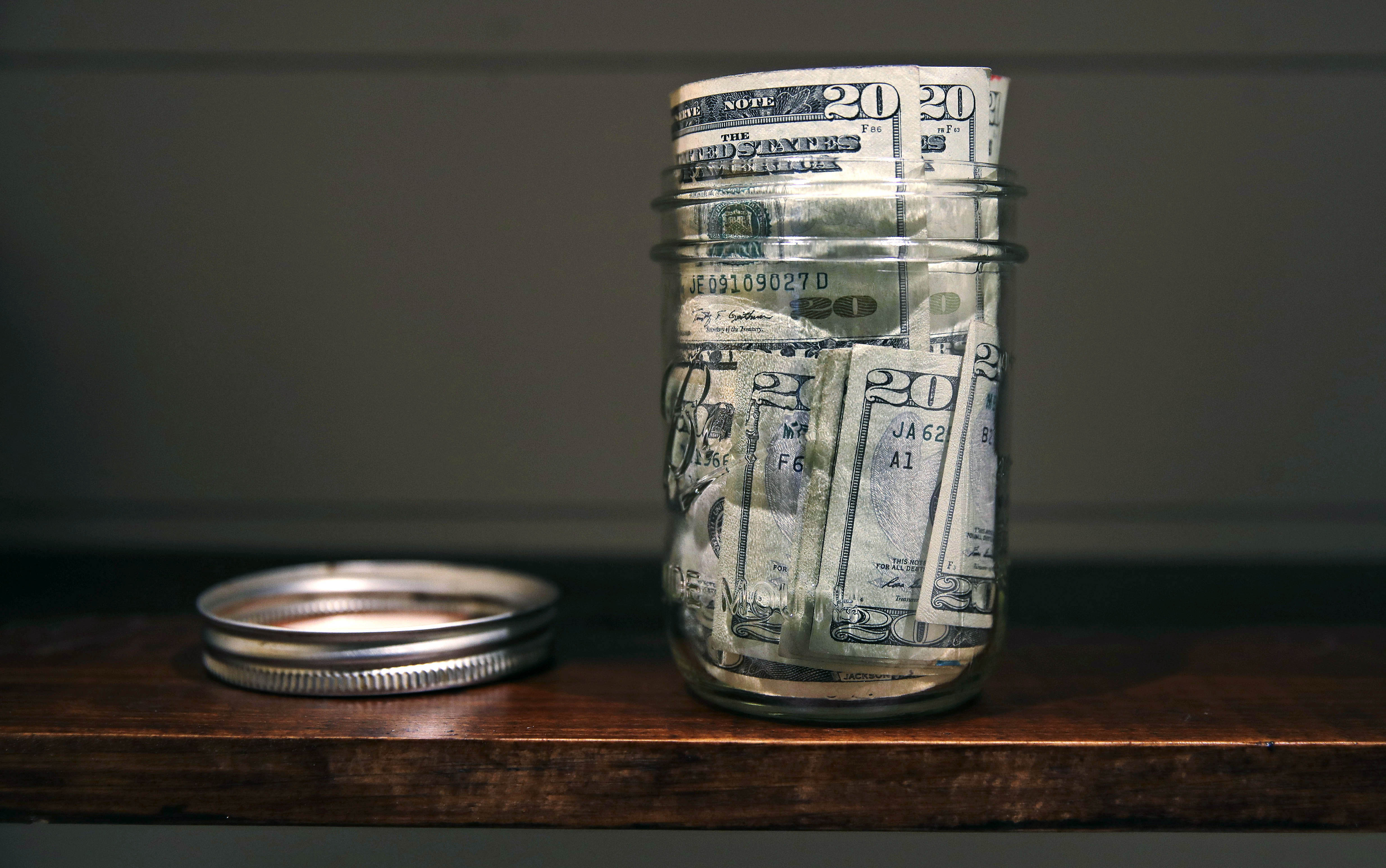 In this June 15, 2018, photo a canning jar filled with currency sits on a shelf in East Derry, N.H. (AP Photo/Charles Krupa)