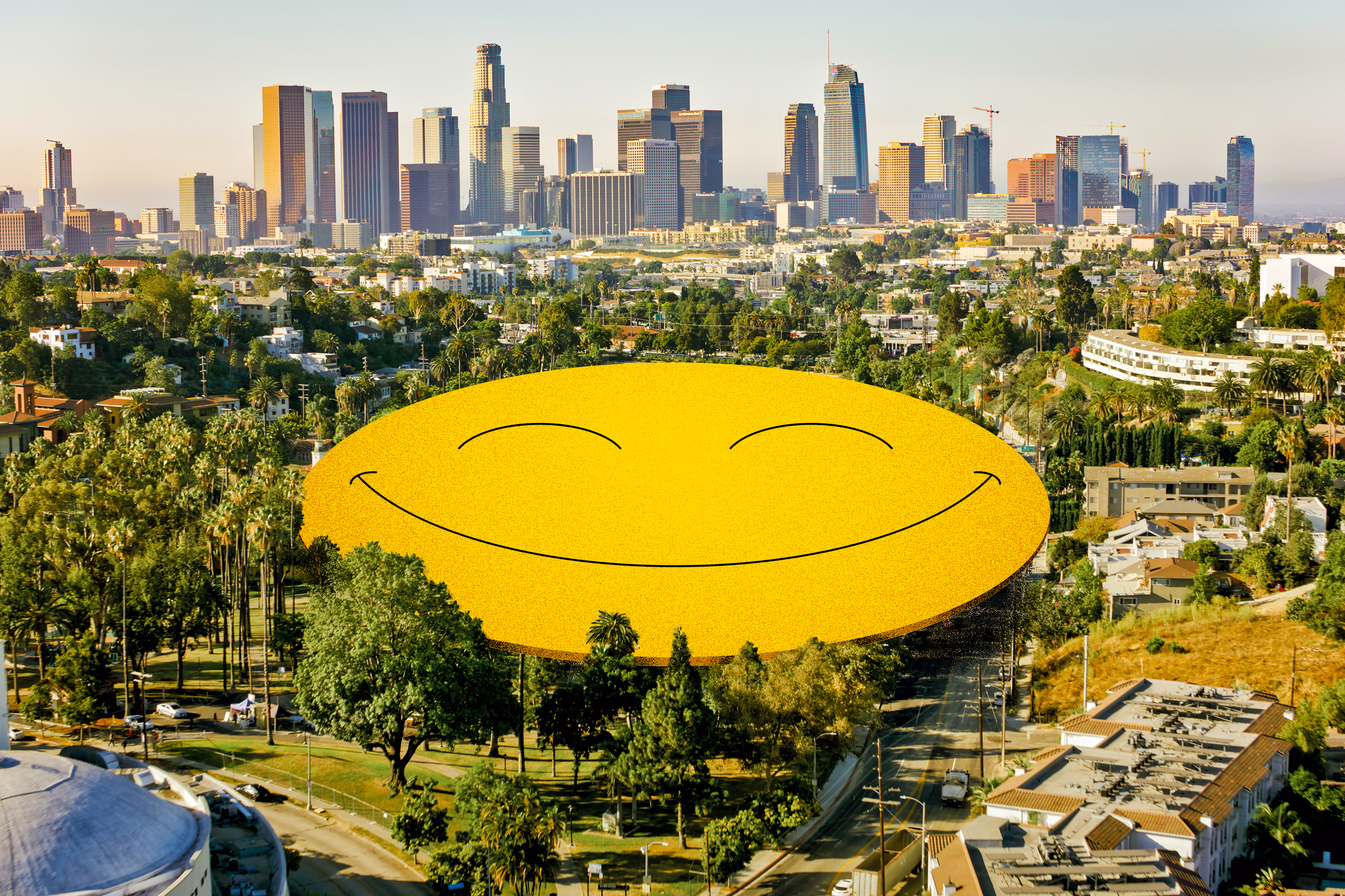 Photo of Los Angeles with the downtown skyline in the background. A yellow grinning happy face covers Echo Lake