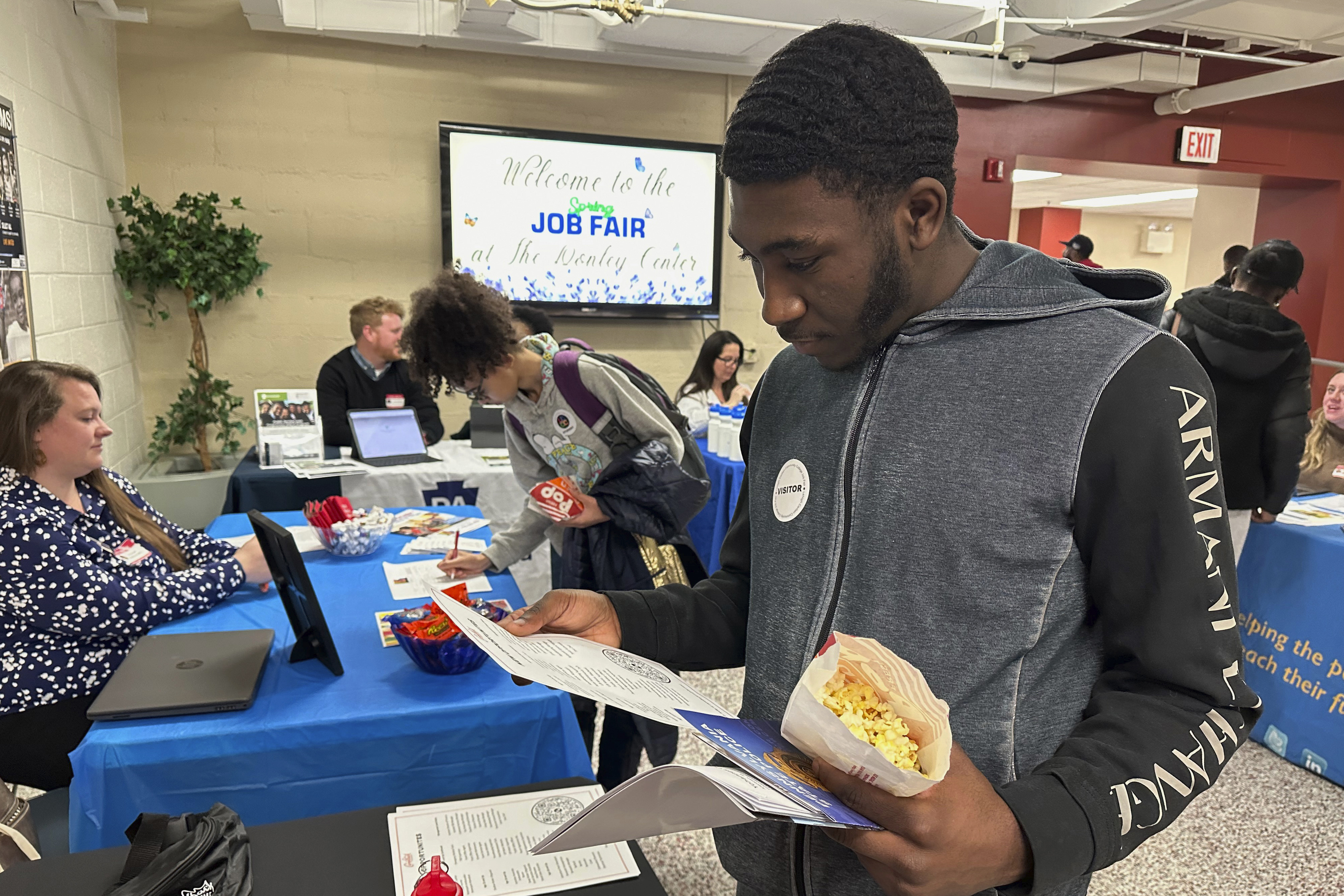 Job seeker Johannes Oveida looks over a brochure at a job fair at Lehigh Carbon Community College in Allentown, Pa., on Thursday, March 7, 2024. On Friday, March 8, 2024, the U.S. government issues its February jobs report. (AP Photo/Michael Rubinkam)