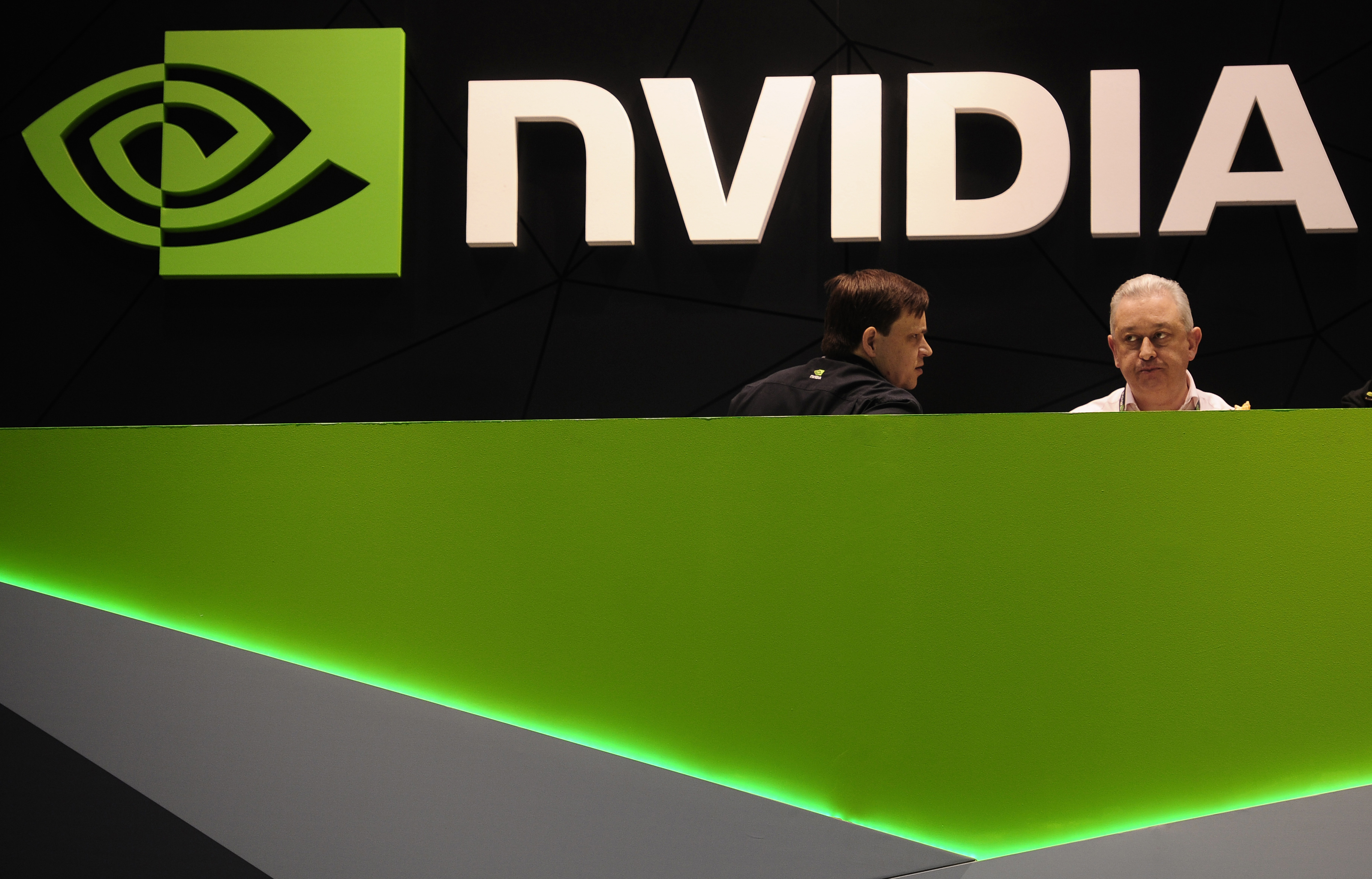 FILE - People gather in the Nvidia booth at the Mobile World Congress mobile phone trade show Thursday, Feb. 27, 2014 in Barcelona, Spain. The Federal Trade Commission on Thursday, Dec. 2, 2021 sued to block graphics chip maker Nvidia’s $40 billion purchase of chip designer Arm, saying the deal would create a powerful company that could hurt the growth of new technologies. (AP Photo/Manu Fernandez, File)