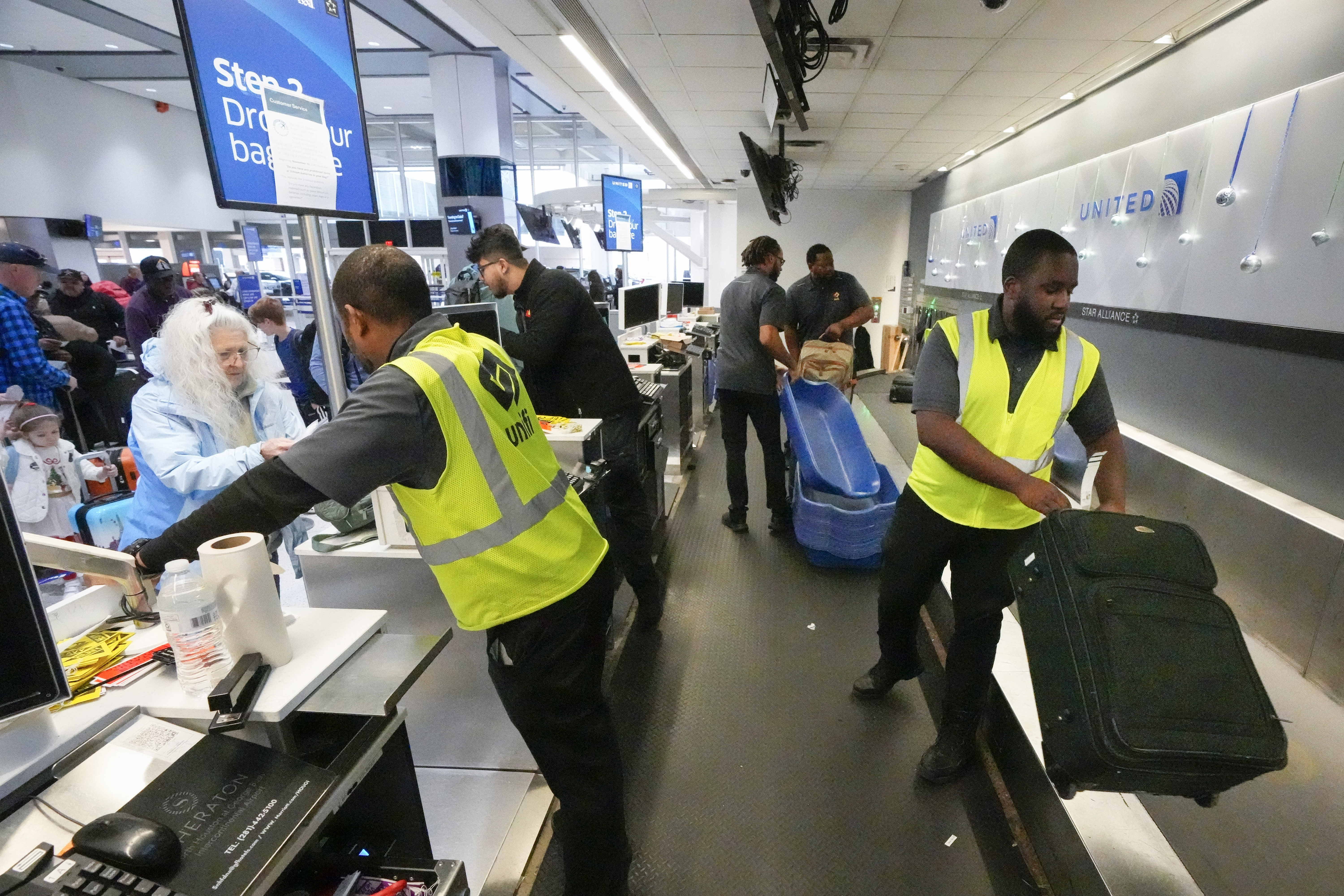 FILE - Passenger drop off their baggage at United Airlines in C Terminal at George Bush Intercontinental Airport, Thursday, Dec. 21, 2023, in Houston. The Biden administration issued final rules Wednesday, April 24, 2024, to require airlines to automatically issue cash refunds for things like delayed flights and to better disclose fees for baggage or canceling a reservation. (Brett Coomer/Houston Chronicle via AP, File)