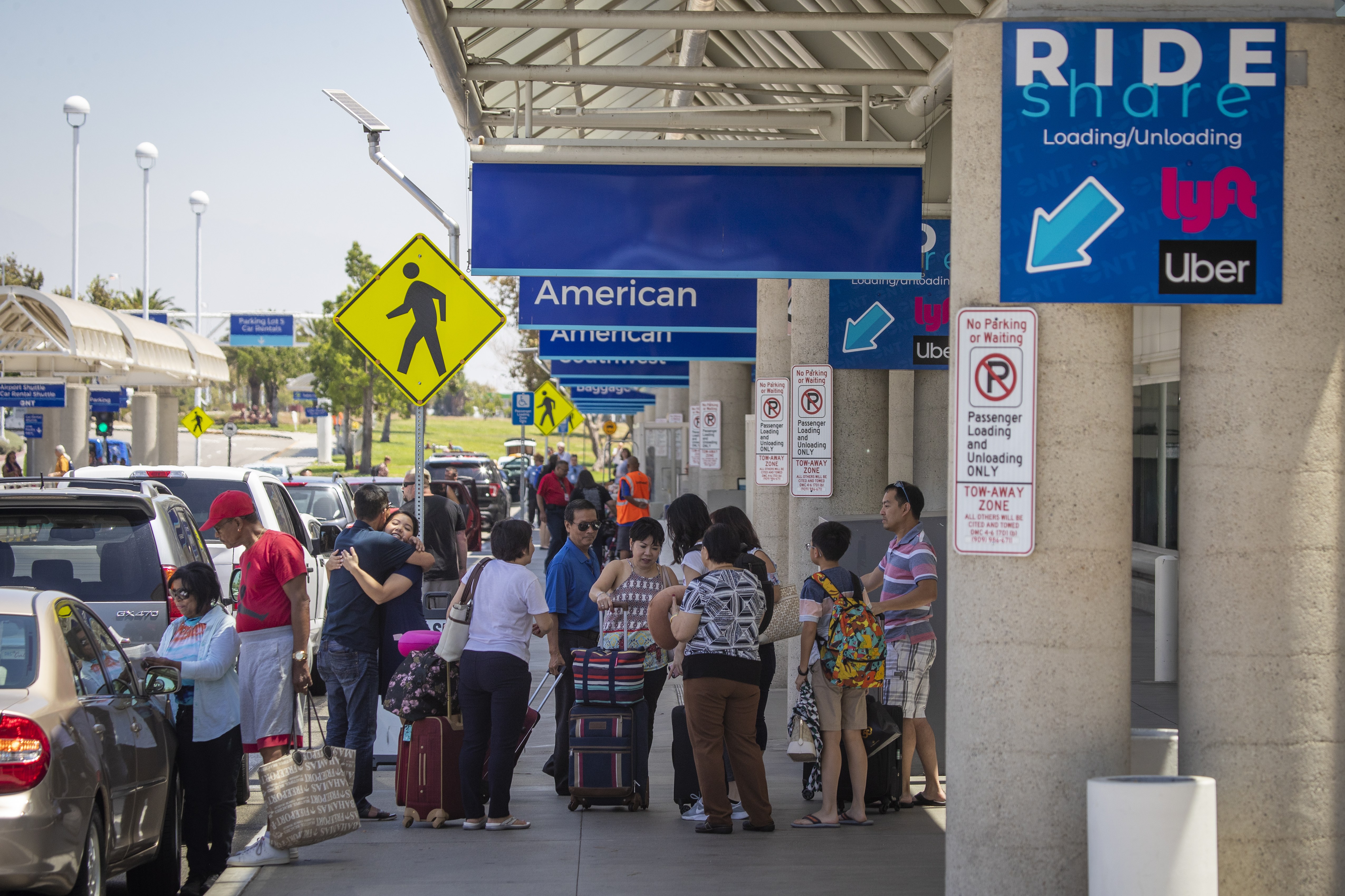 ONTARIO, CALIF. -- MONDAY, AUGUST 12, 2019: Travelers arrive in the ride-share pick up location at Ontario International Airport in Ontario Monday, Aug. 12, 2019. Uber said it will stop its service at Southern CaliforniaÕs Ontario International Airport because of fee increases. The airport said Lyft will stay. (Allen J. Schaben / Los Angeles Times)