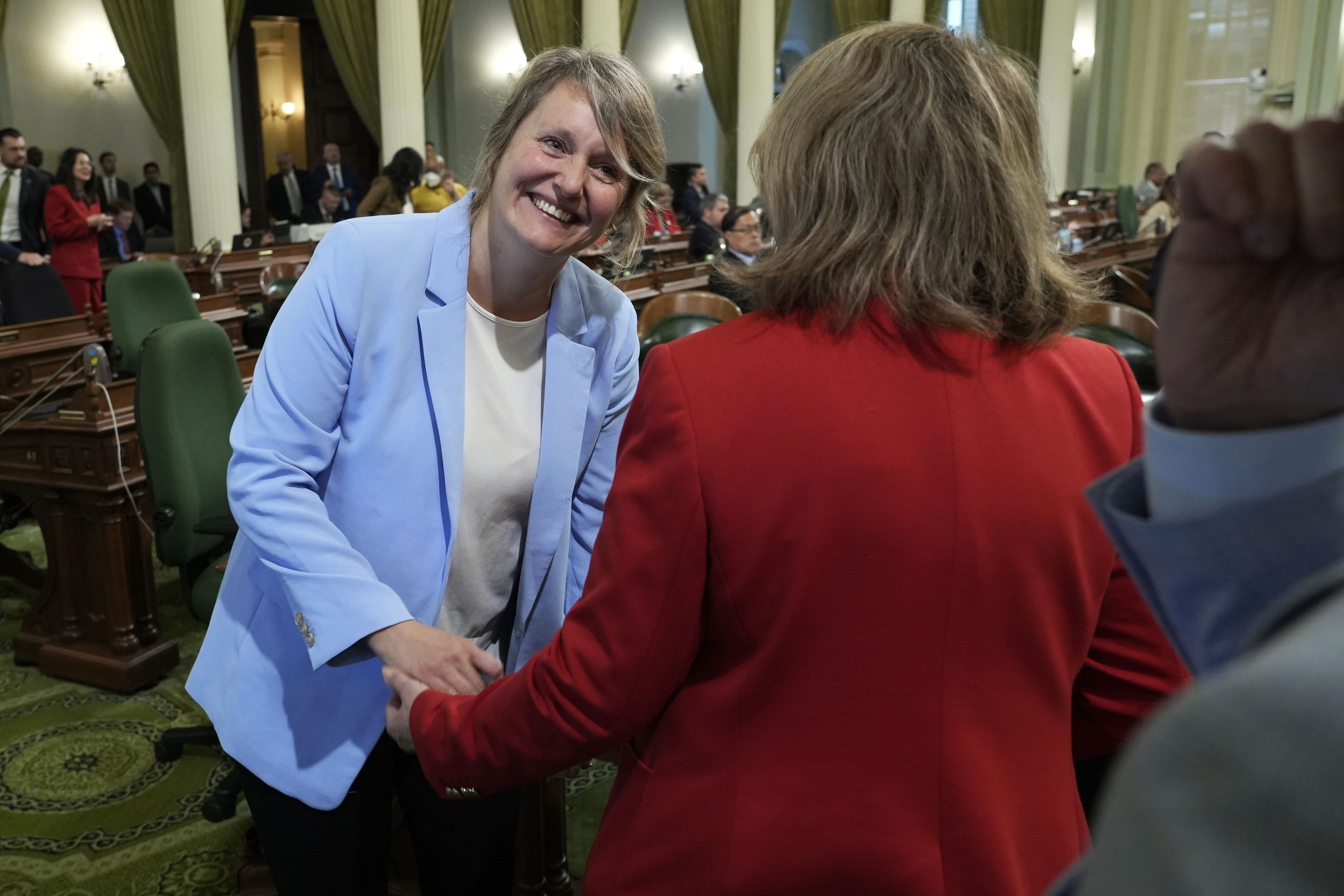Assemblywoman Buffy Wicks, left, D-Oakland, is congratulated by Assemblywoman Eloise Gomez Reyes, D-Colton, after Wicks' measure that would force Big Tech companies to pay media outlets for using their news content was approved by the Assembly at the Capitol in Sacramento, Calif., Thursday, June 1, 2023. The measure now goes to the Senate for consideration. (AP Photo/Rich Pedroncelli)