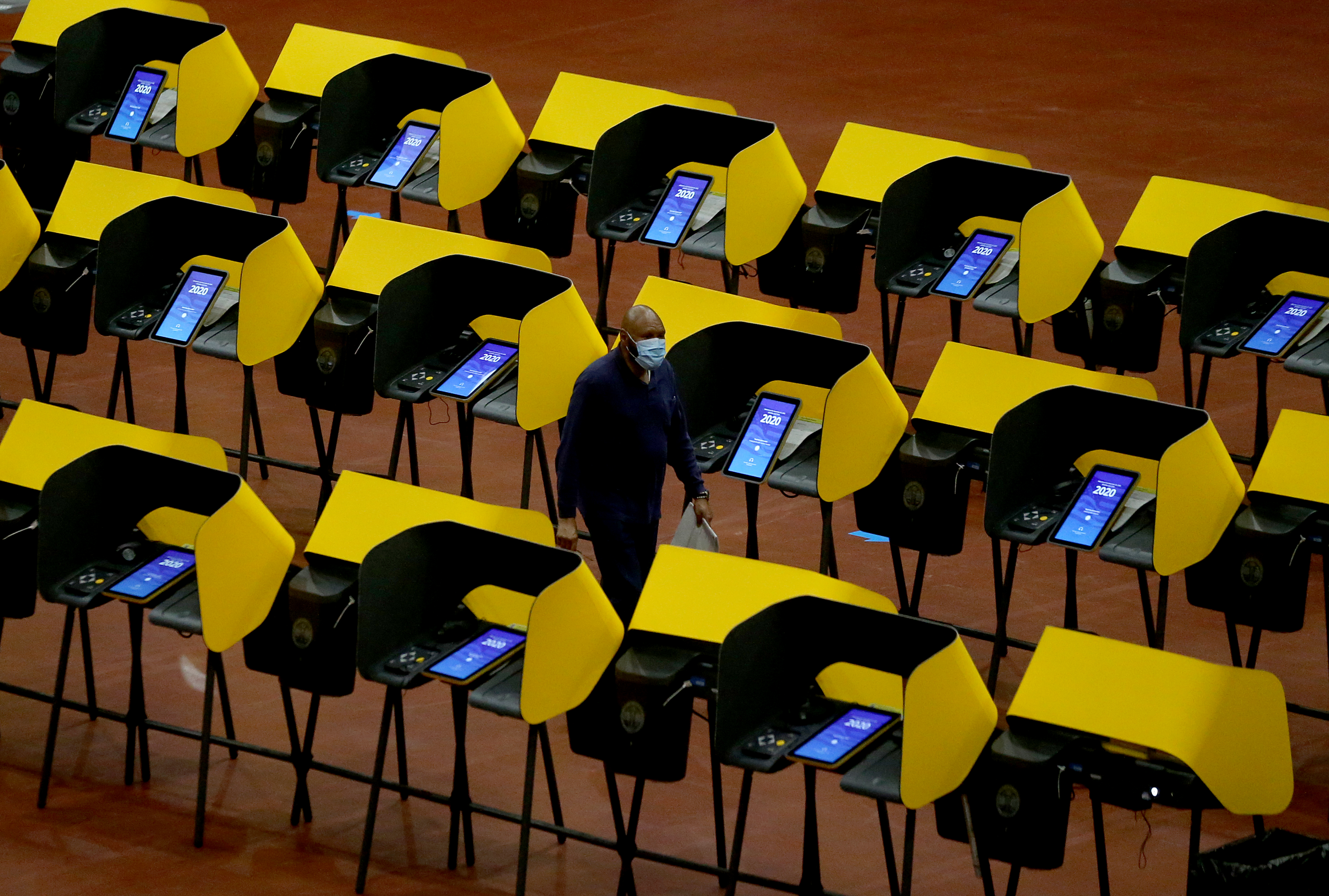 INGLEWOOD CA - OCT. 30, 2020. A voter walks through voting booths after casting his ballot at the Forum, which was open for early voting on Friday, Oct. 30, 2020. (Luis Sinco / Los Angeles Times)