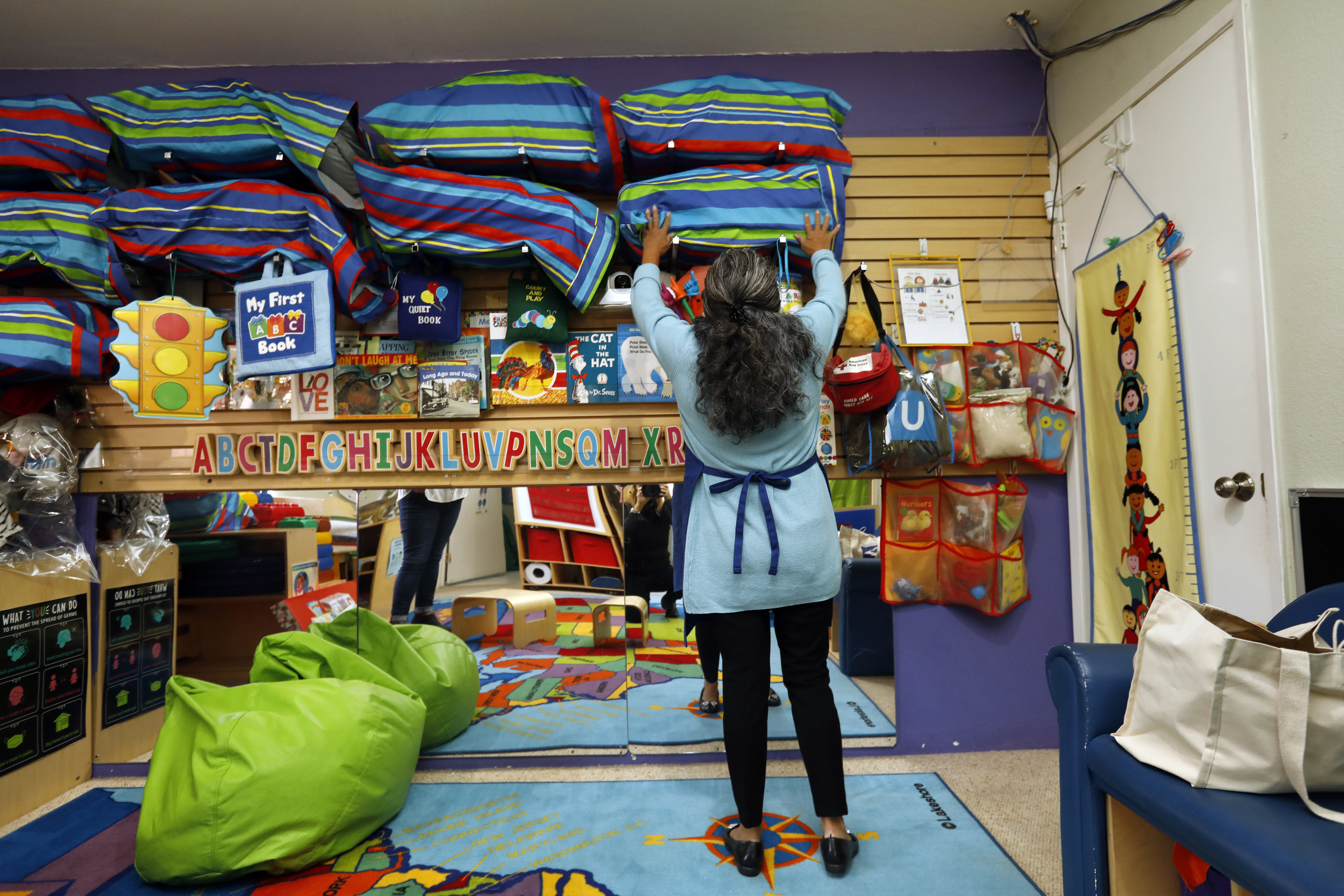 Hawthorne, Los Angeles, California-Nov. 31, 2021-Leonila Irias, center, runs a child care center called Irias Family Childcare, from her home in Hawthorne, California. Many additional precautions have been added to keep everyone safe in the child care center, including designated sleeping mates for each child. (Carolyn Cole / Los Angeles Times)