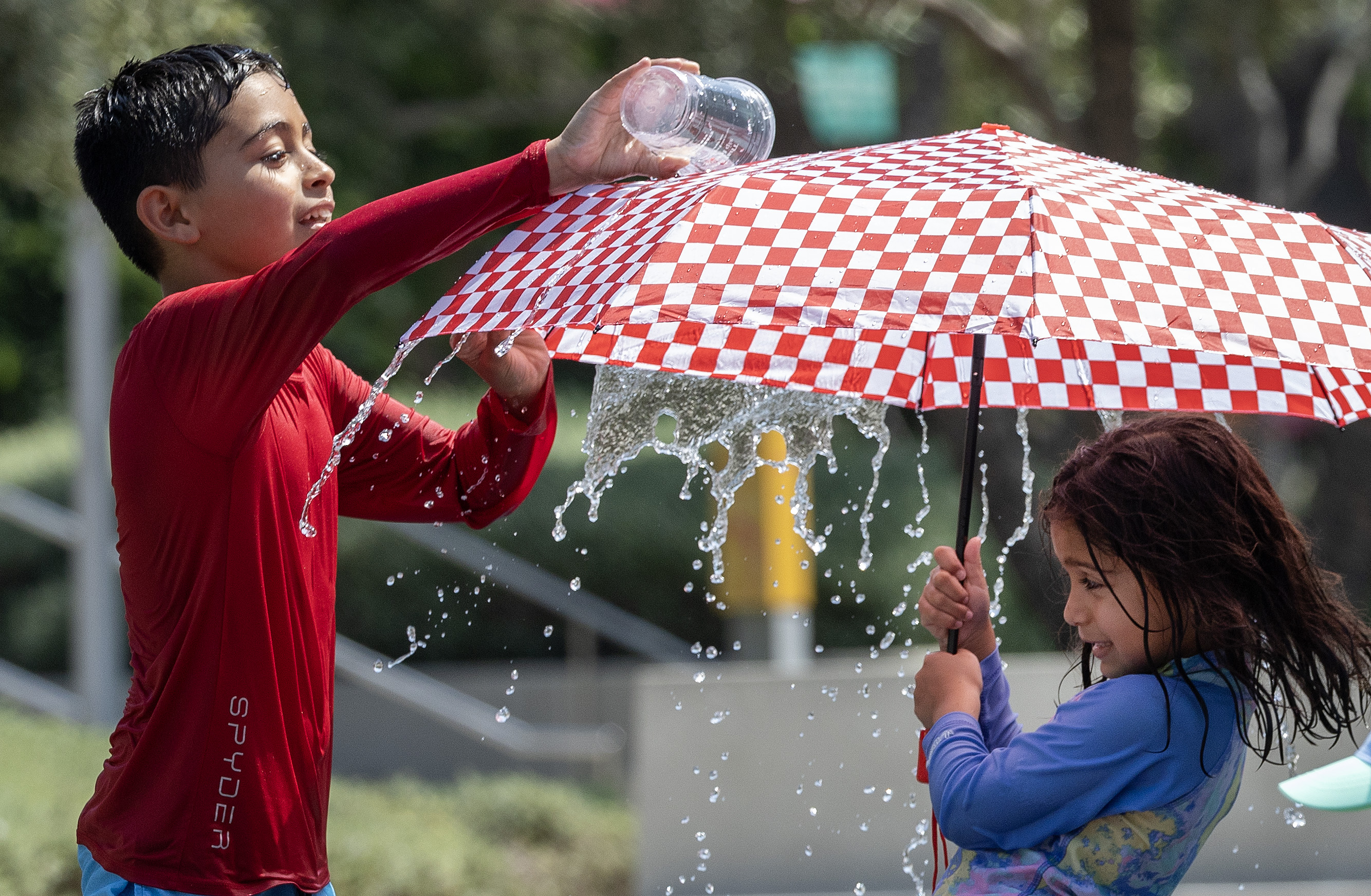 LOS ANGELES, CA - SEPTEMBER 07: Dean Lagunas, 9, cools off with his sister Delilah, 6, in the Arthur J. Will Memorial Fountain at Grand Park while attending a friend's birthday party on Saturday, Sept. 7, 2024. (Myung J. Chun / Los Angeles Times)