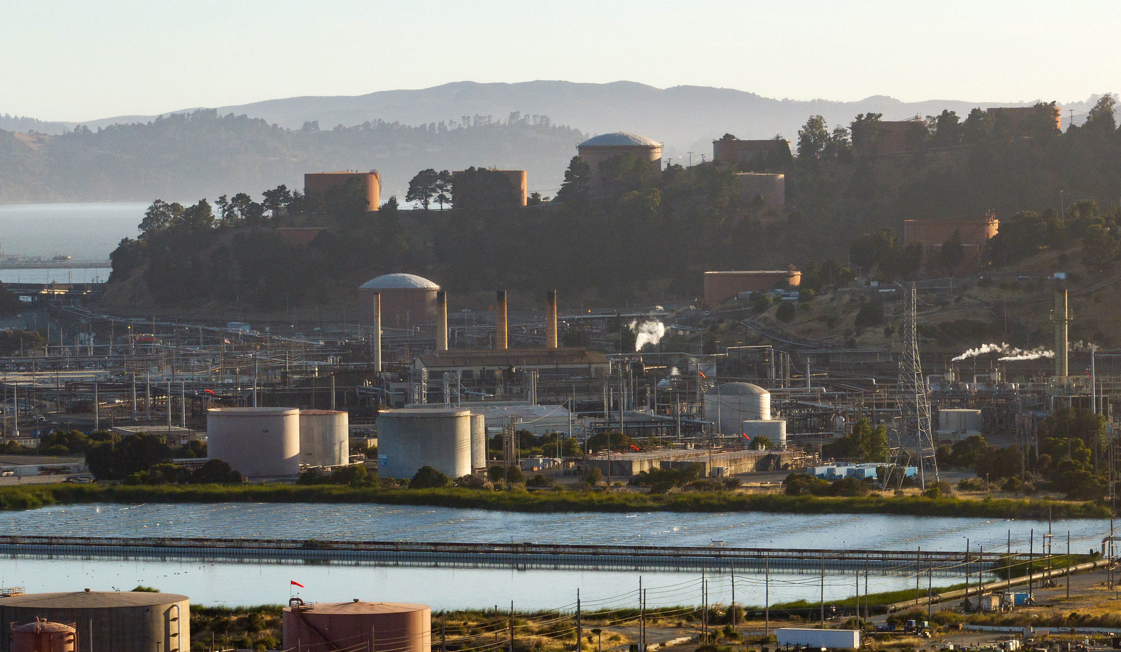 RICHMOND, CALIFORNIA - JUNE 18: In this aerial view, part of the Chevron refinery is seen in Richmond, California on June 18, 2024. The city of Richmond, California is considering a tax that will cost Chevron $1 per barrel and will raise approximately $30-$50 million. Supporters of the tax say Chevron is poisoning their air and causing local residents to get sick. Chevron says the city is trying to make up for budget shortfalls and will cost everyone more at the pumps. (Josh Edelson / For the Times)