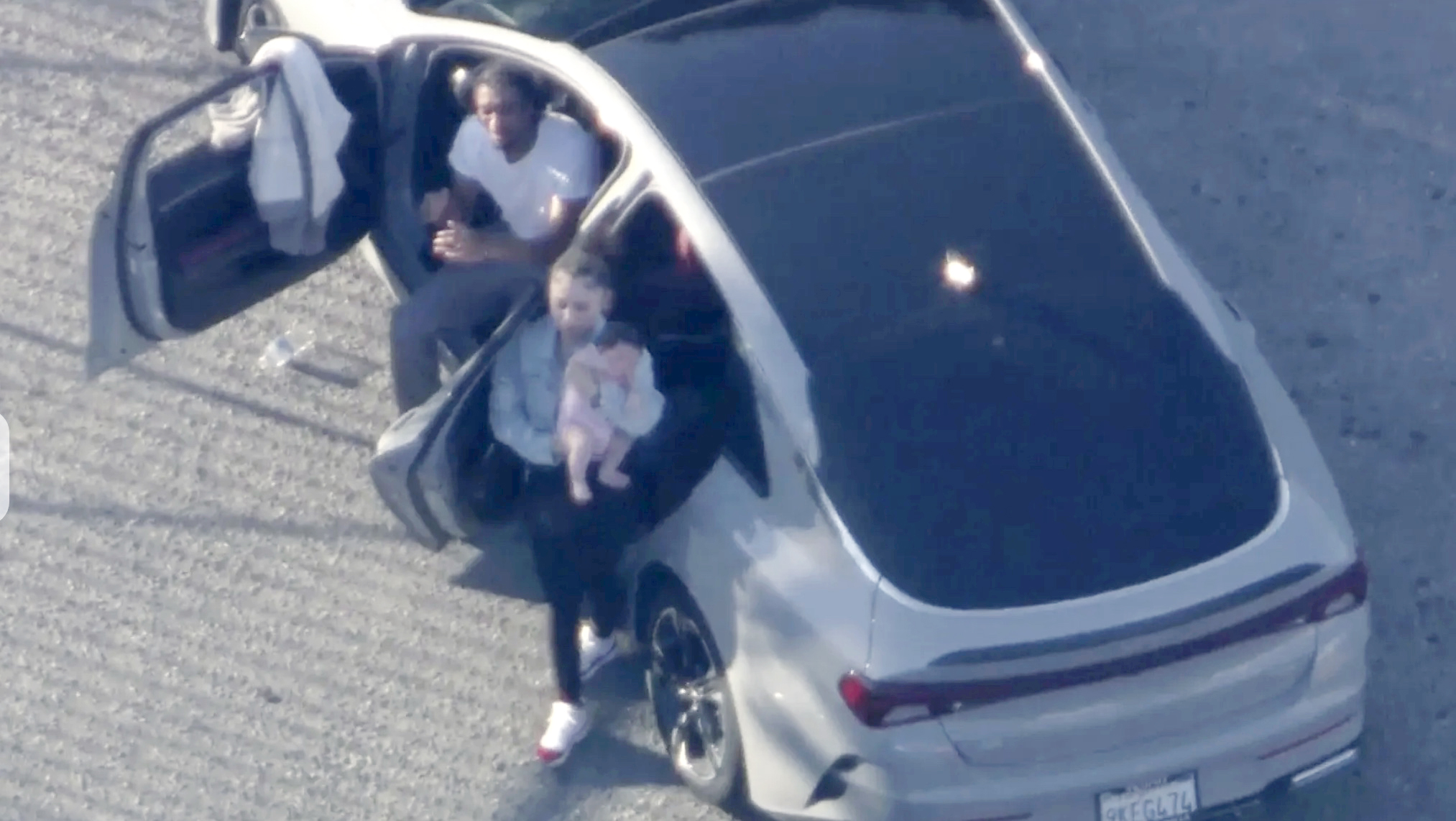 A female passenger in a suspect car that led police in chase seen exiting the vehicle with an infant on July 17, 2024. 