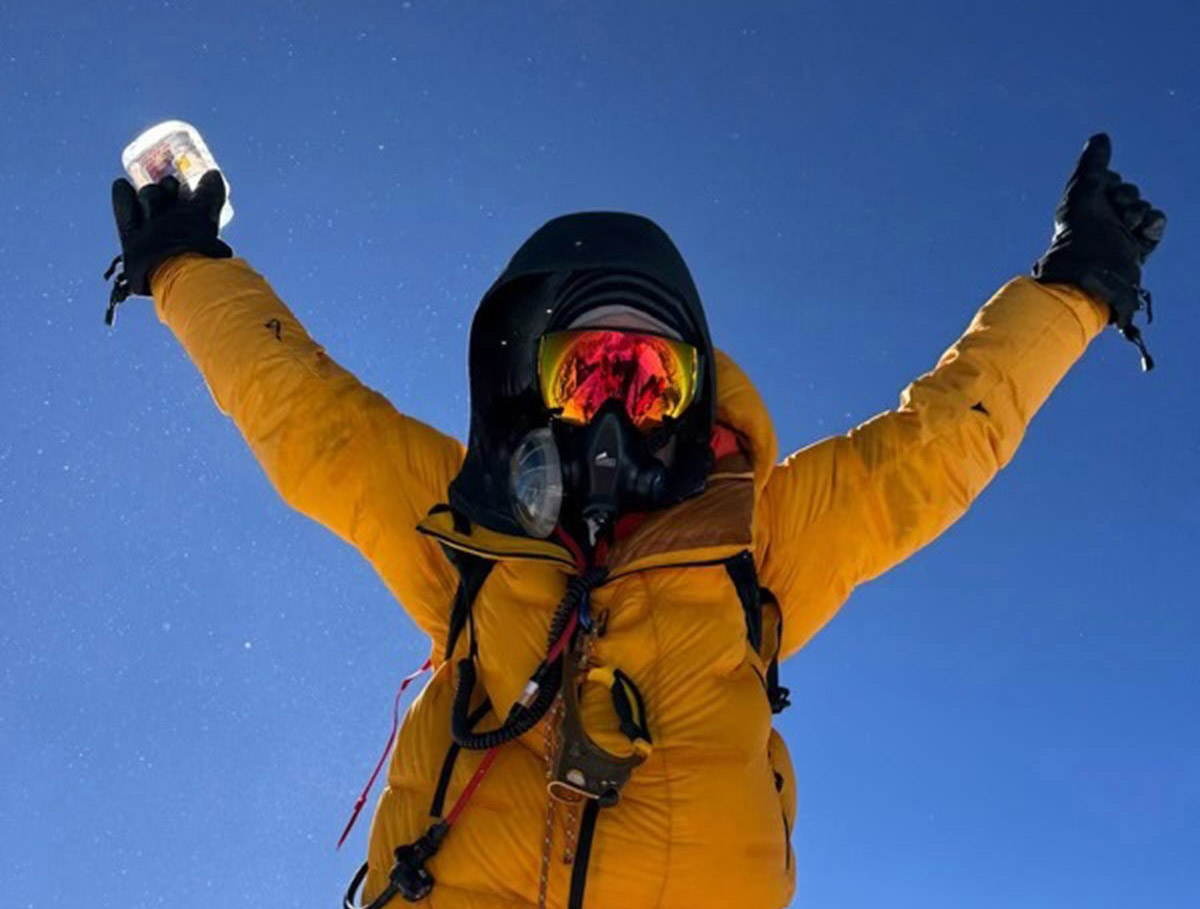 Graham Cooper raises his arm after reaching the summit of Mt. Everest.