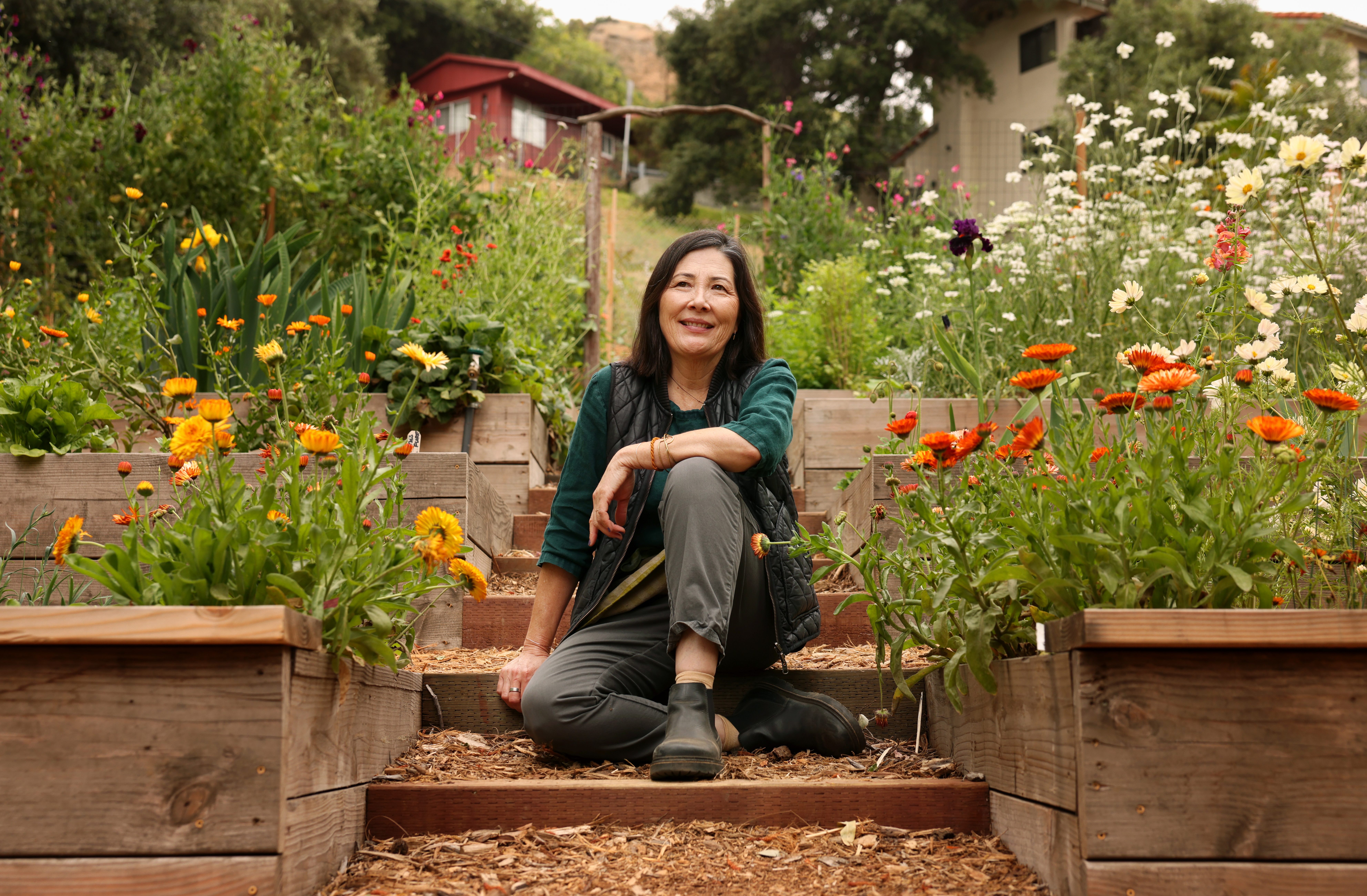 L.A. landscape designer Kathleen Ferguson sits surrounded by flowers in wooden planter boxes