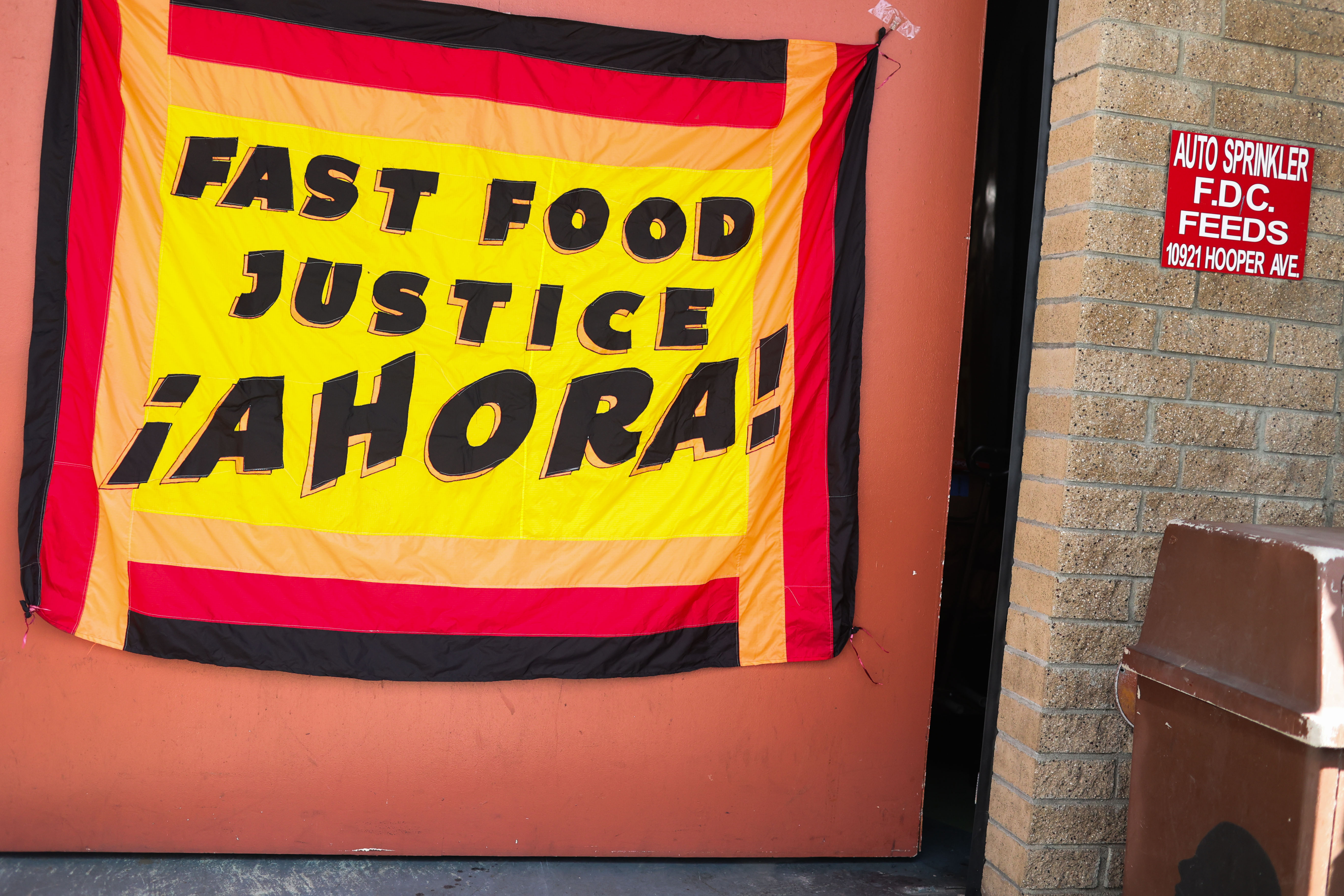 Watts, CA - February 9: A sign is displayed saying "Fast Food Justice. Ahora!," during a California Fast Food Workers Union meeting at Watts Labor Community Action Committee on Friday, Feb. 9, 2024 in Watts, CA. (Michael Blackshire / Los Angeles Times)