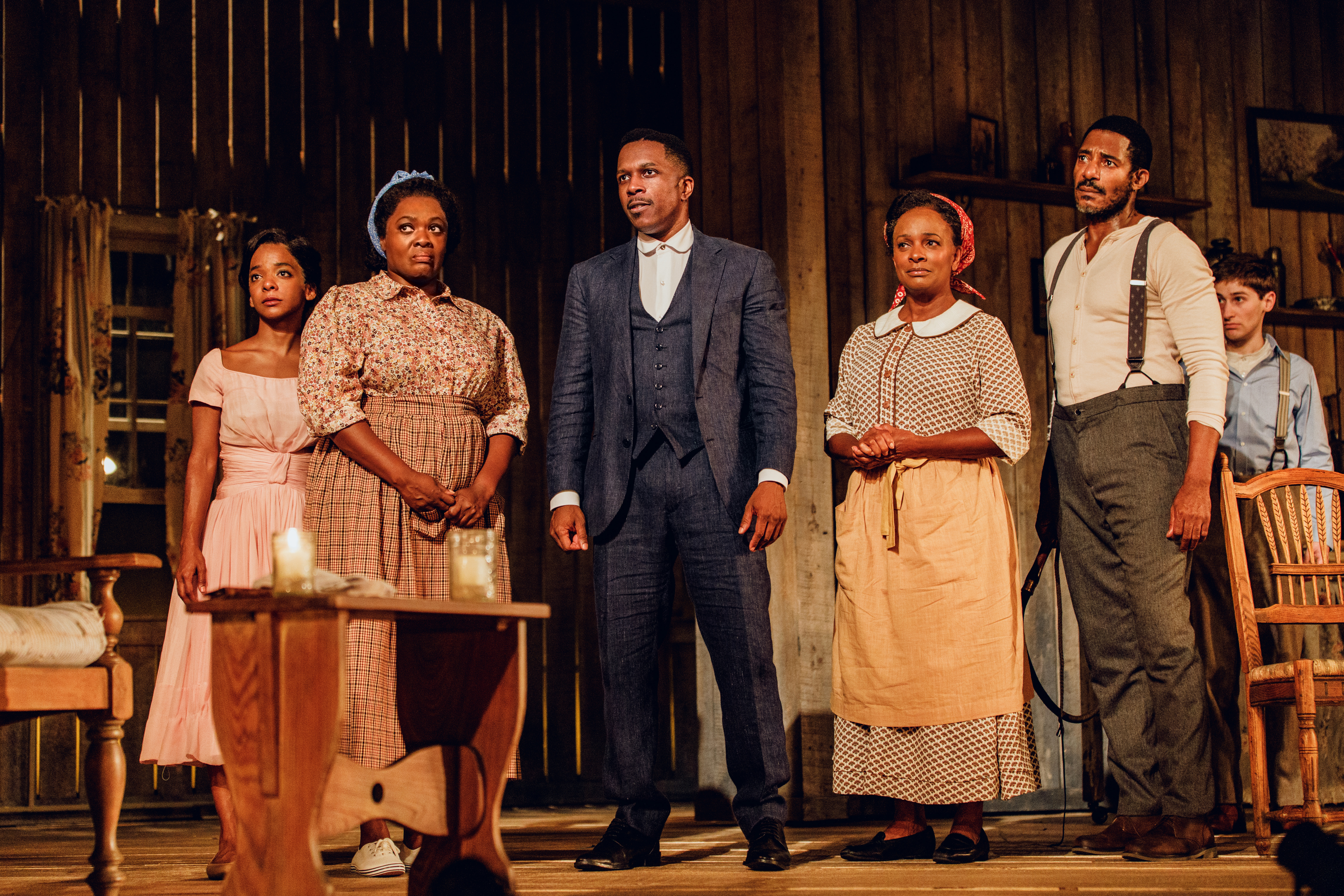 Actors standing onstage with stern faces