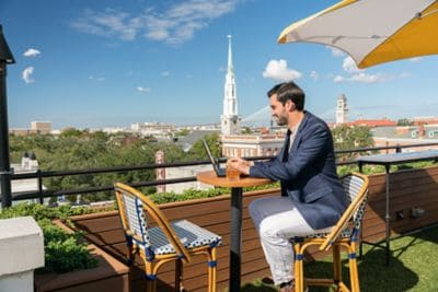 man works on laptop while enjoying a rooftop view