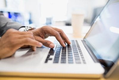 Close up of laptop with hands on keyboard.