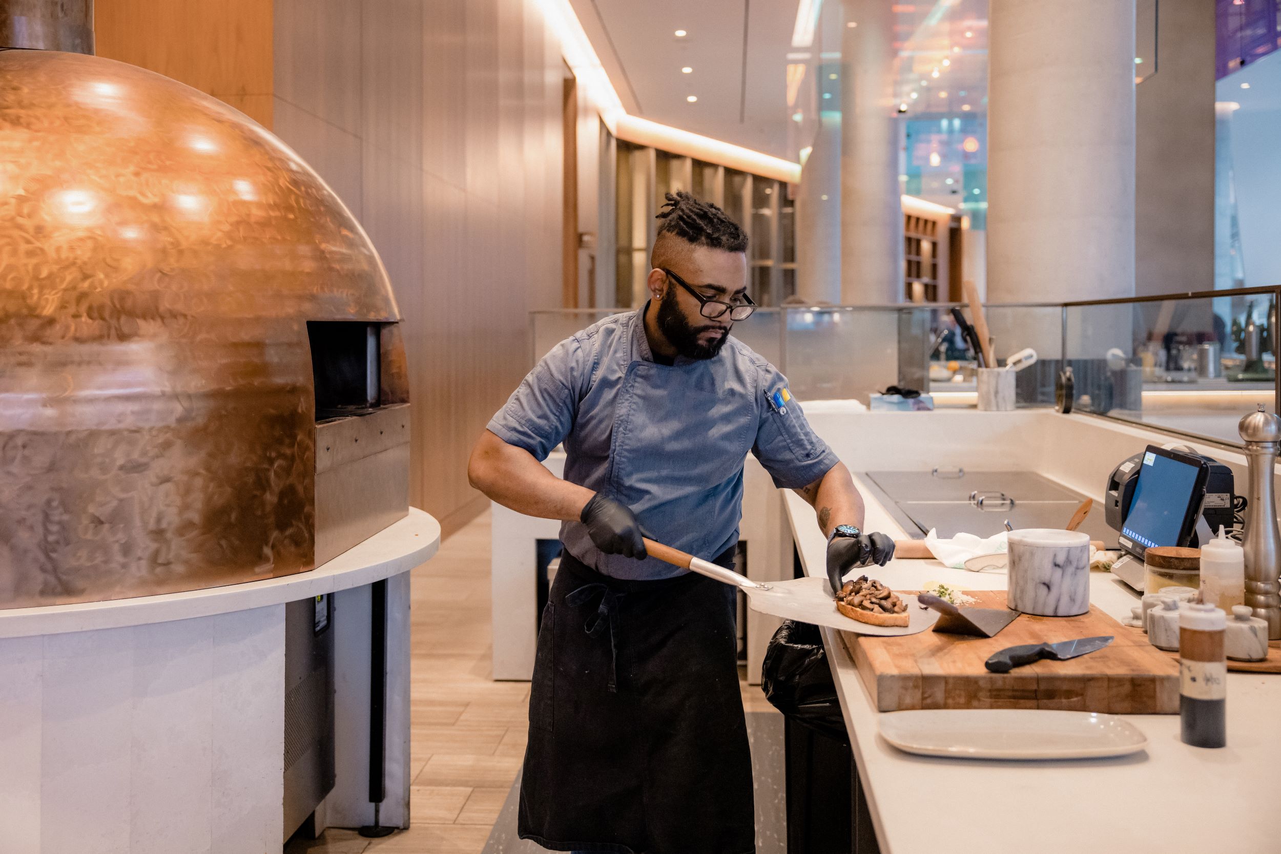 Pizza chef with pie fresh out of brick oven