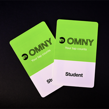 Two green Student OMNY Cards on a black background.