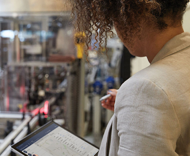 Mulher a monitorizar processos industriais num tablet digital.