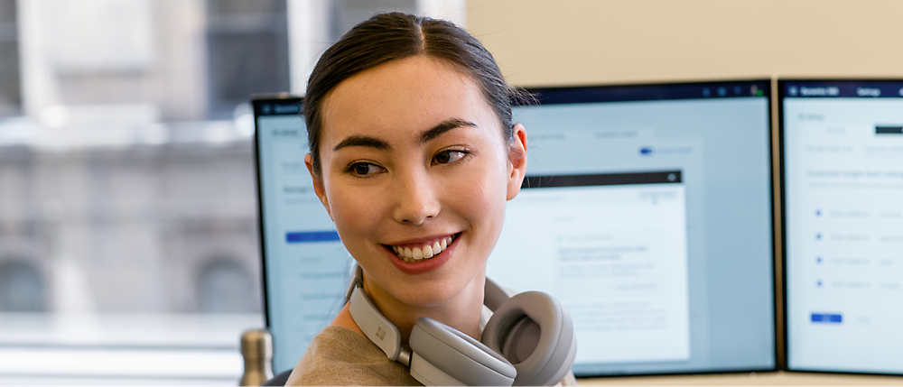 Una persona sonriendo con auriculares alrededor del cuello