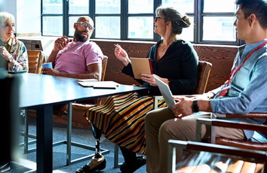 Mature woman leading team meeting in a conference room.