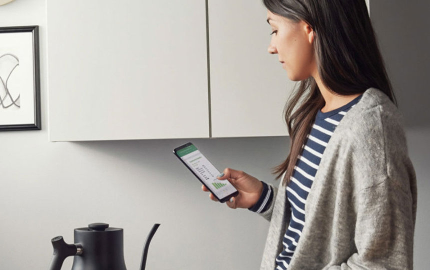 Woman drinking coffee while looking at phone