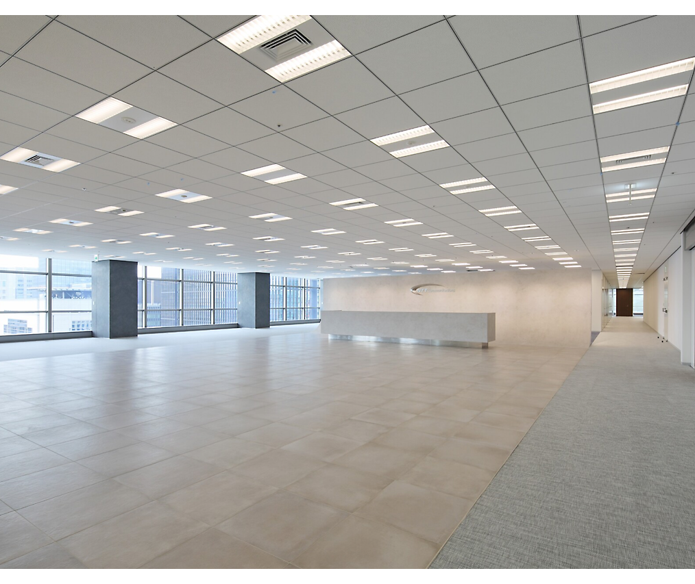 現代且空無一物的辦公室空間，帶有磚頭地板、白色牆面和大型窗戶，讓自然光線進入