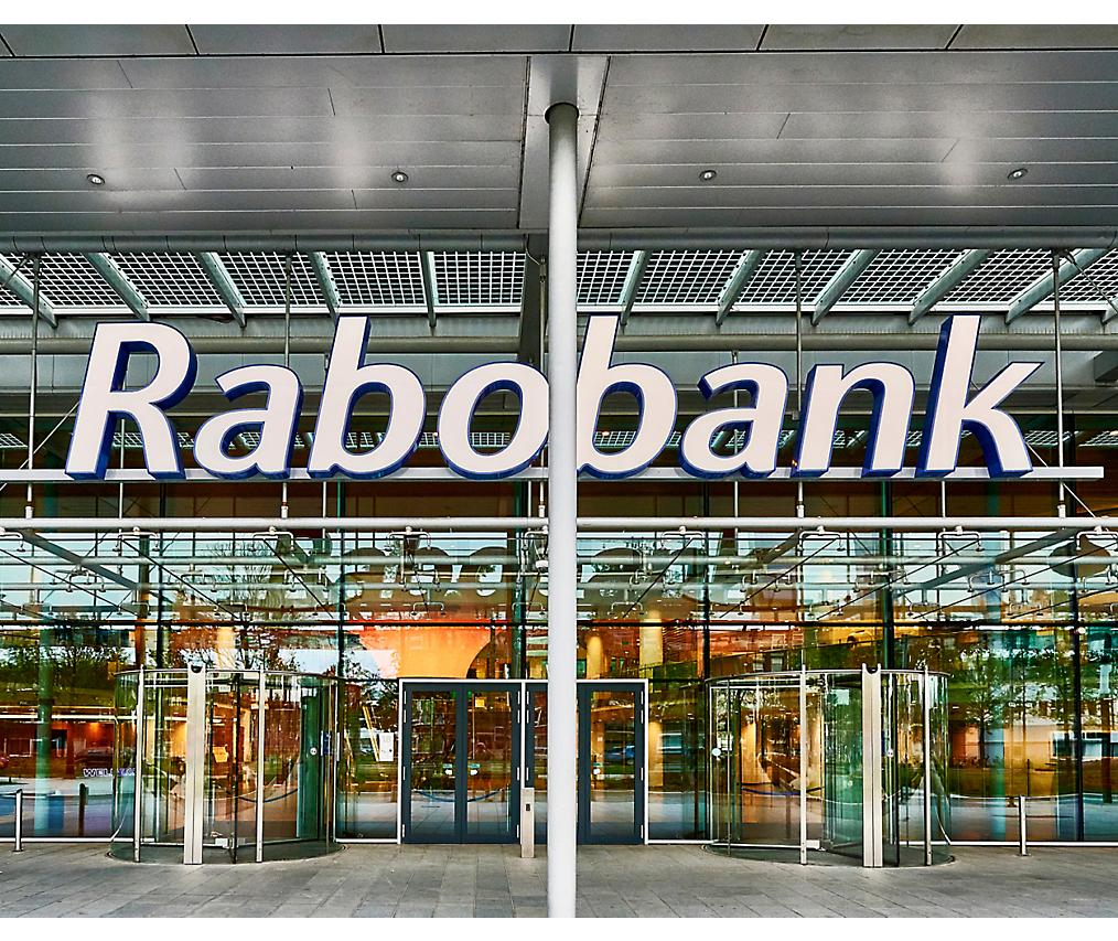 Rabobank 大樓的外部景觀，帶有玻璃門，且入口上方有顯示銀行名稱的大標誌。