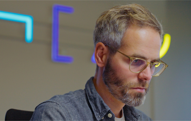 A man in glasses sitting at a desk