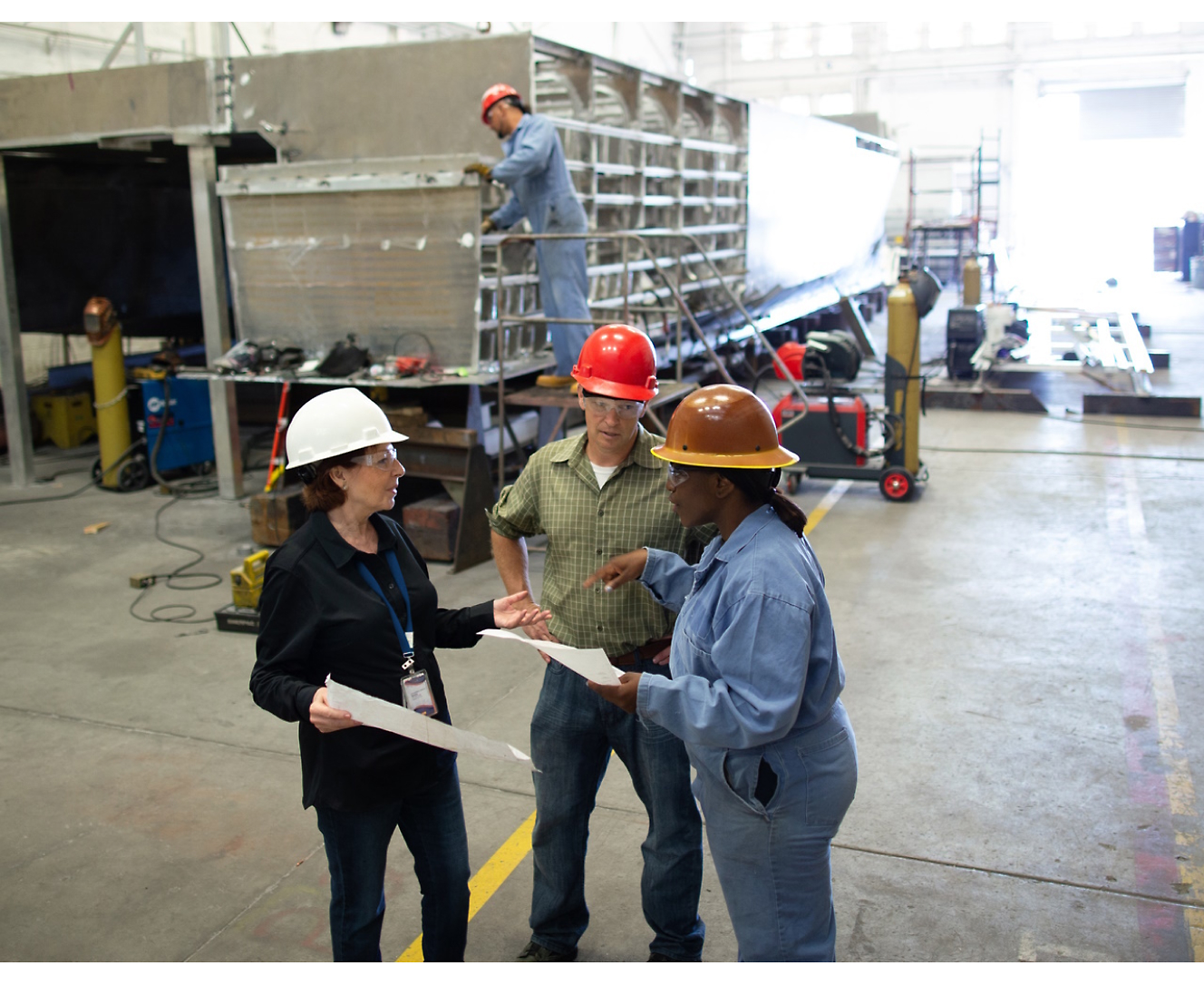 Group of people wearing safety helmets and discussing at a construction site