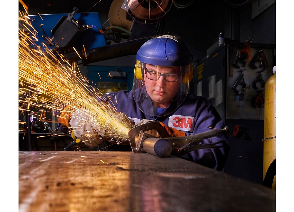 A men wearing helmet and safety jacket using gas cutter