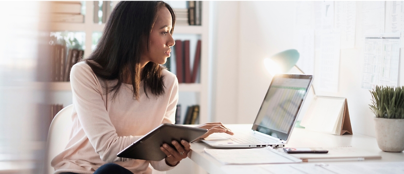 A woman sitting at a desk with a laptop.