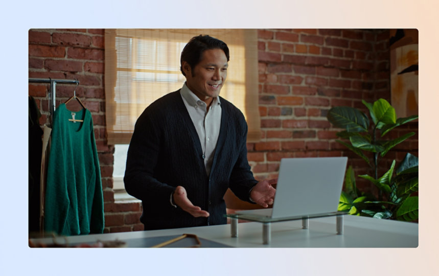 Man in home office talking to coworker on laptop