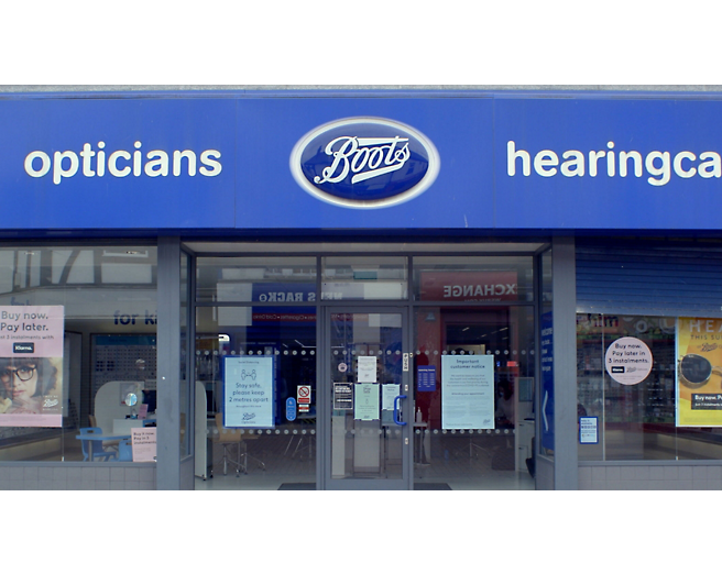 The front of a boots store with a blue sign.