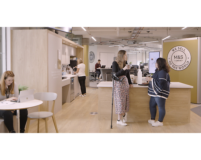 A group of people standing in an office.