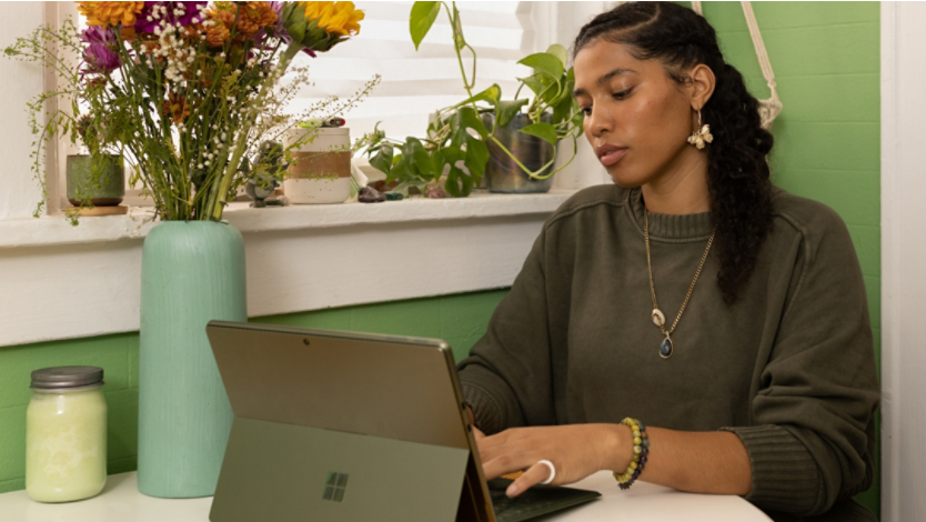 A woman sitting at a table using a laptop computer