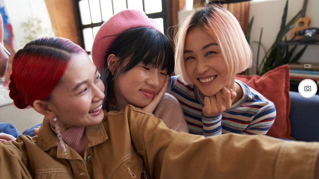 Three young women taking a photo or video