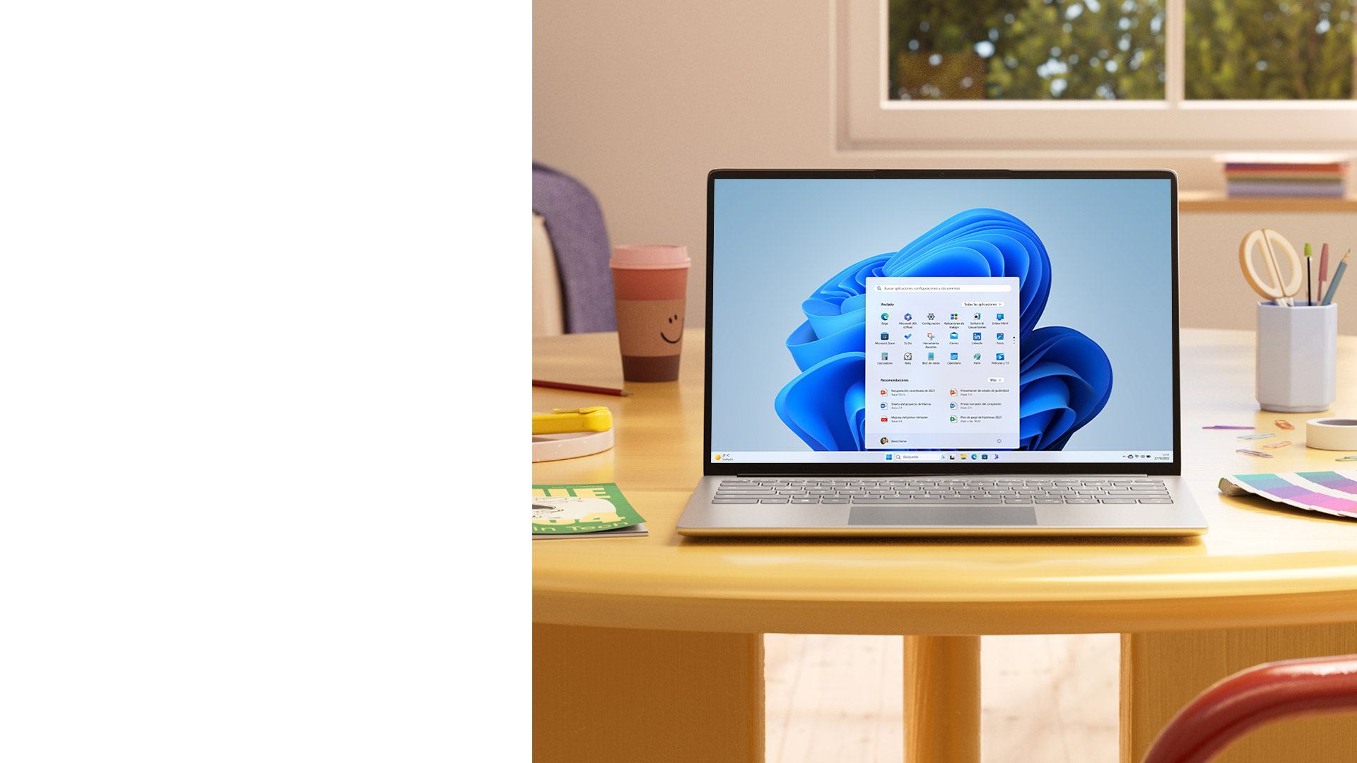 Un PC Windows 11 con el menú Inicio, sobre una mesa