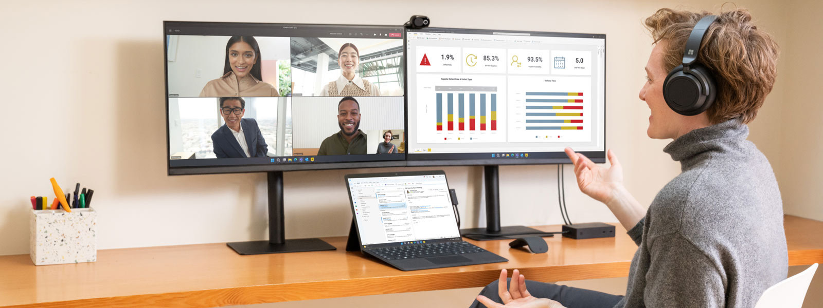 Woman using a Surface device and two monitors while in a virtual meeting