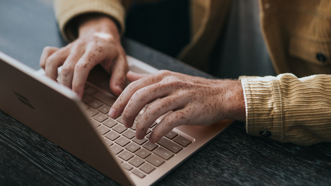 Surface laptop on a table with Surface Arc Mouse and Surface Earbuds