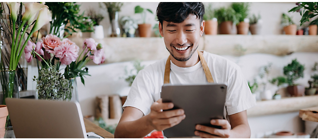 A person is using a tablet and smiling. 