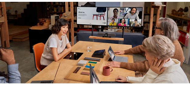 Four person's sitting around a table and talking with each other