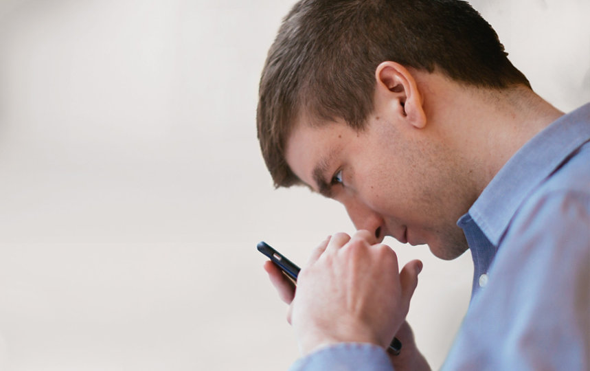 A man looking closely at his phone screen 