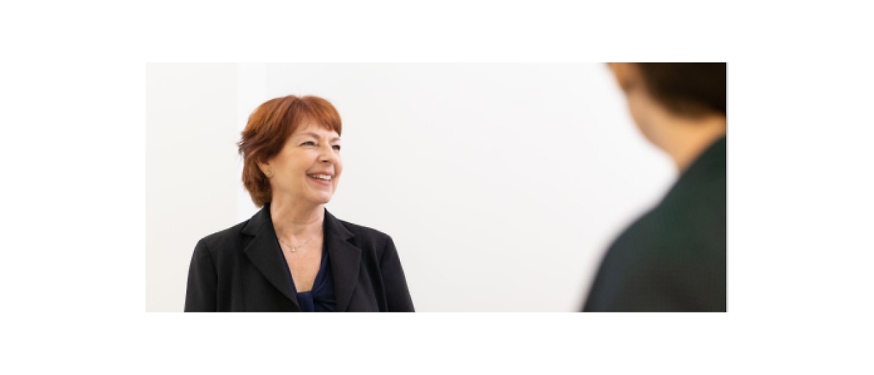 A woman is talking to another woman in a business suit.