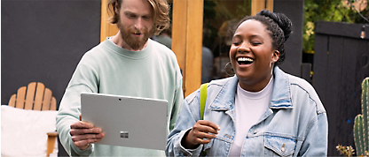 Microsoft Surface 태블릿을 들고 웃고 있는 남녀.