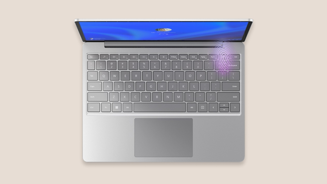 Top view of platinum Surface Laptop Go 3 with the fingerprint reader illuminated in the top-right corner of the keyboard.