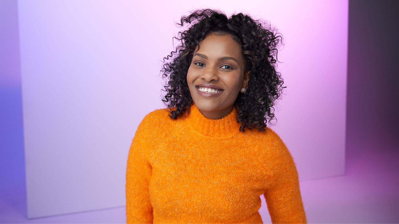 A woman with curly hair standing 