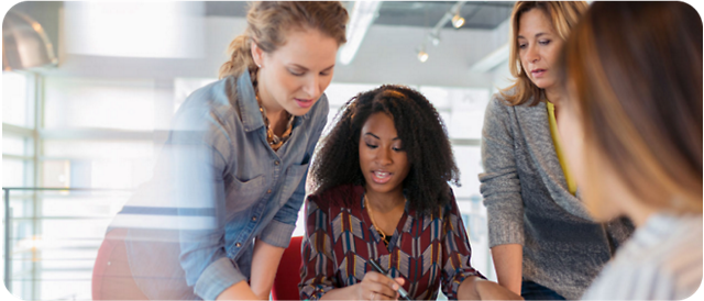 A group of women discussing something in a workplace