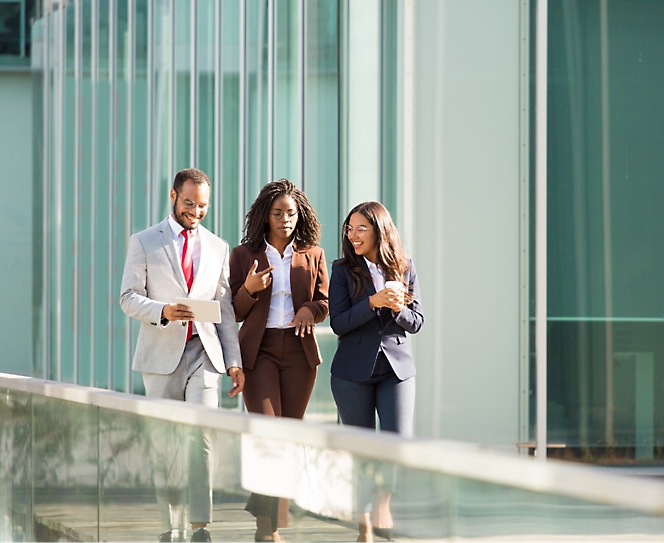 A group of people walking in an office with formal wear.