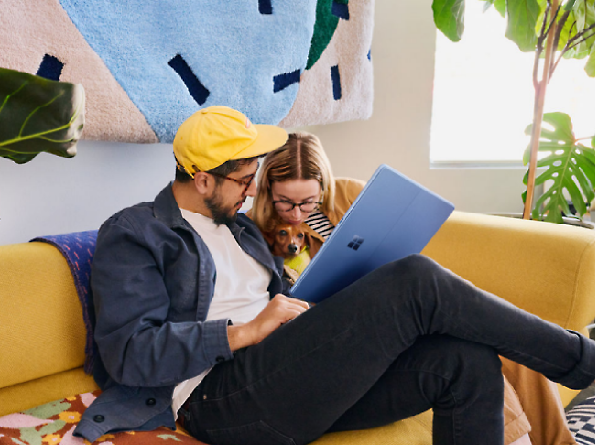 The two people sitting on a couch with a computer