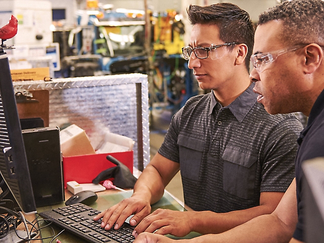 Engenheiro a inspecionar componentes eletrónicos num laboratório de alta tecnologia.